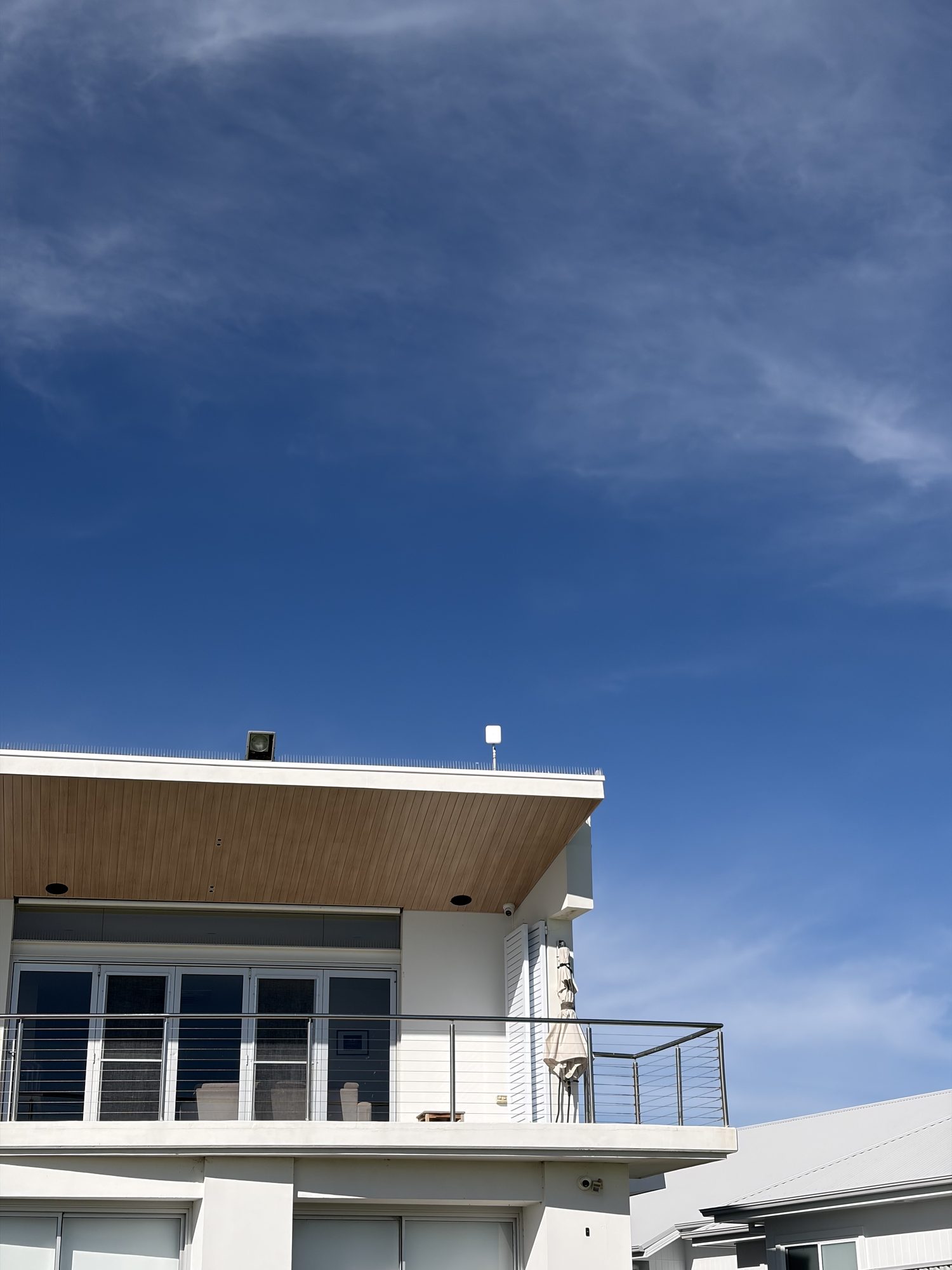 A weatherproof exterior access point mount at Hindmarsh Island, the bracket fixed square to the wall with the cable entry sealed and dressed behind it